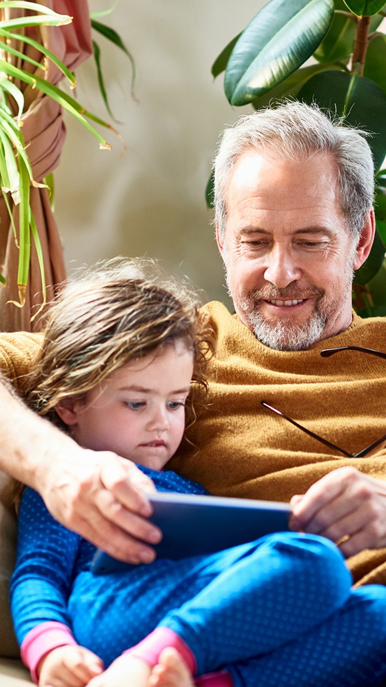 Father reading to daughter from a tablet