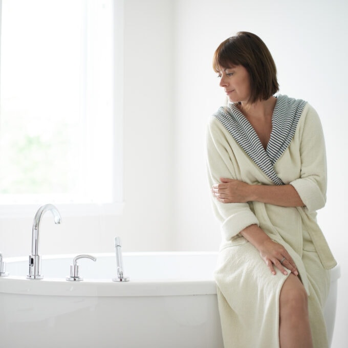 Serene mature woman sitting by a bathtub